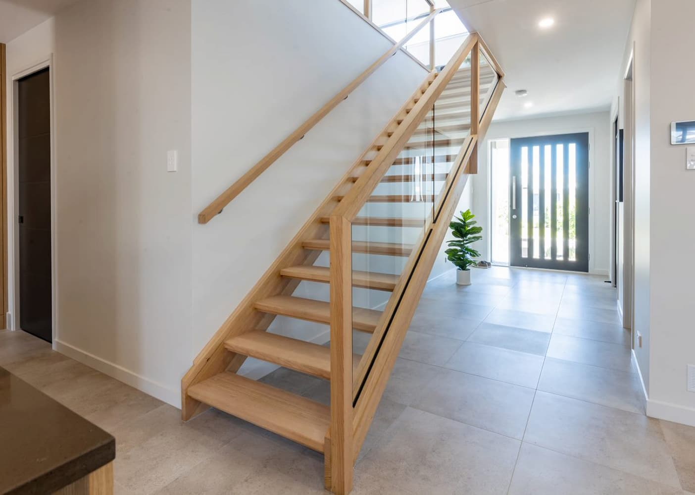 modern wooden and glass stairs in an entryway