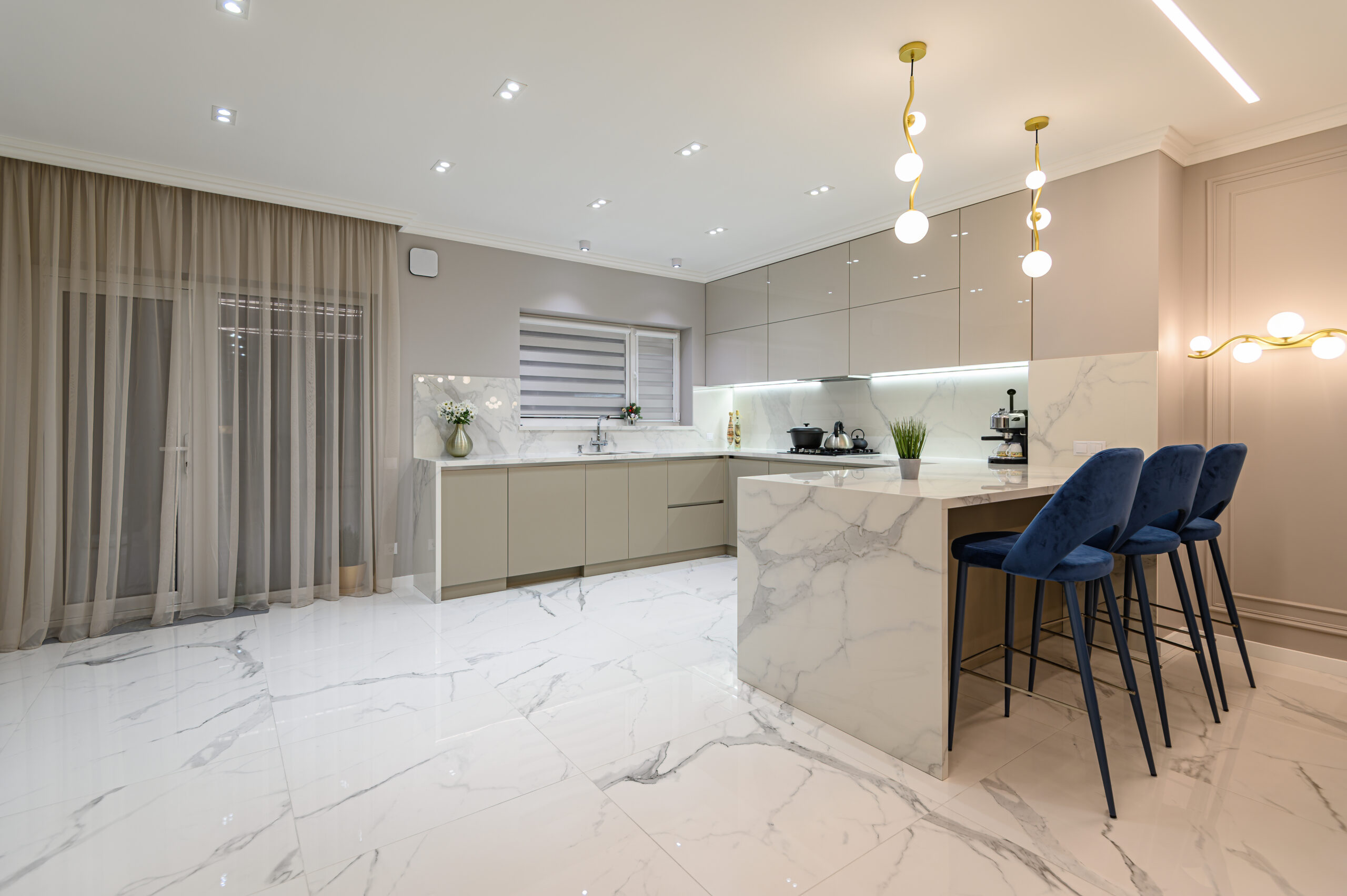 Luxury white modern marble kitchen in studio space with simple curtains and blinds